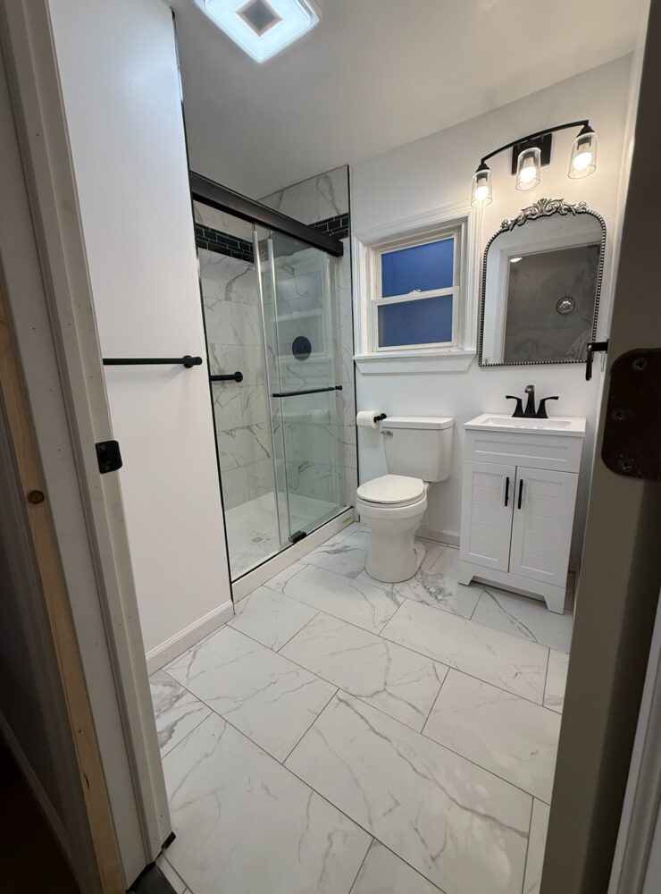 The same bathroom after Eclipse: bright white walls with a finished tile shower and new fixtures